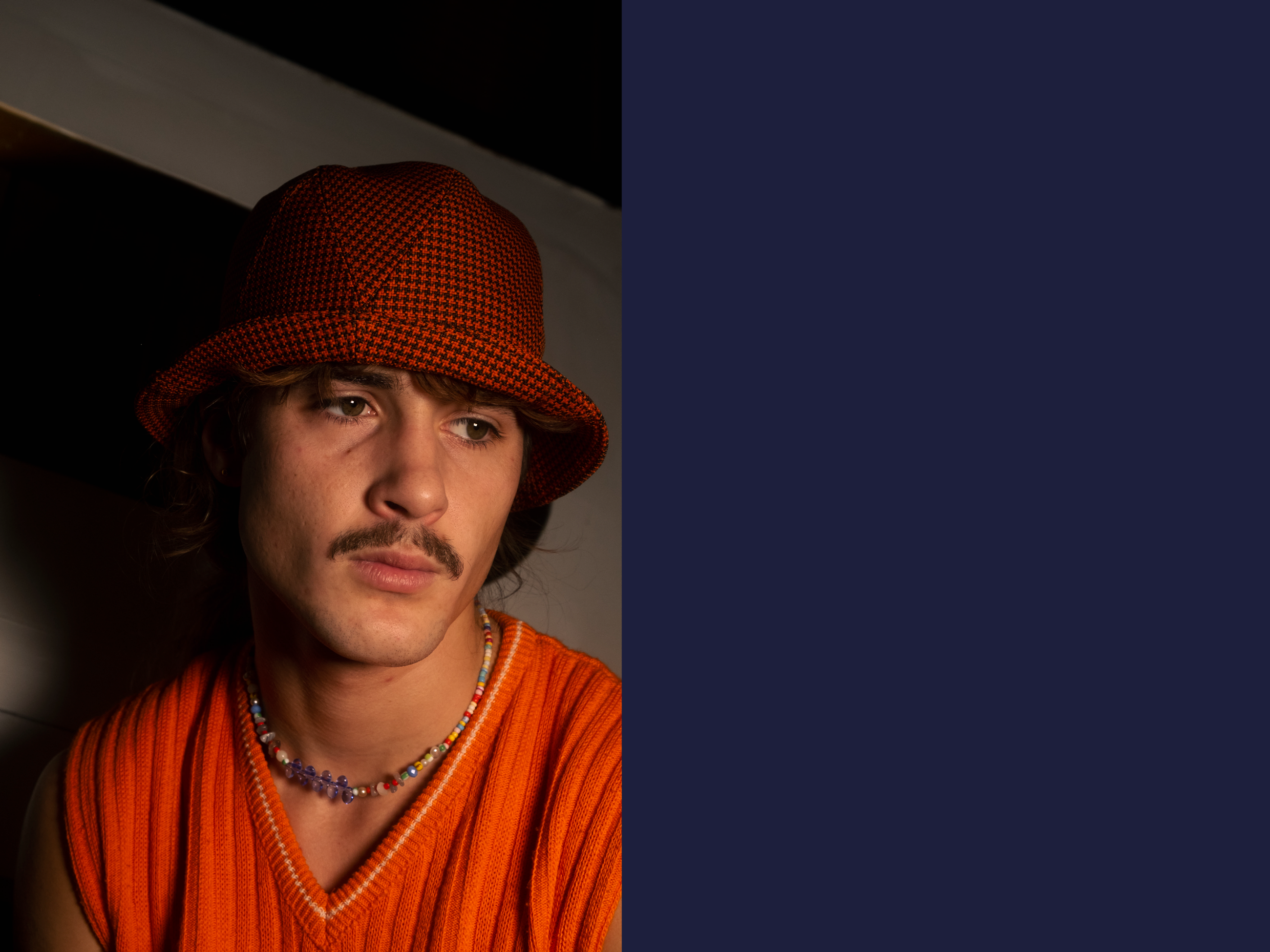 N°97_Trevira cs orange brown Boby_Le Panache Paris© Paul is wearing a Le Panache Paris© bucket hat made in France with Go Couture_63080, Gabriel© brand fabric, 100% Trevira cs, brown houndstooth pattern on a orange background.