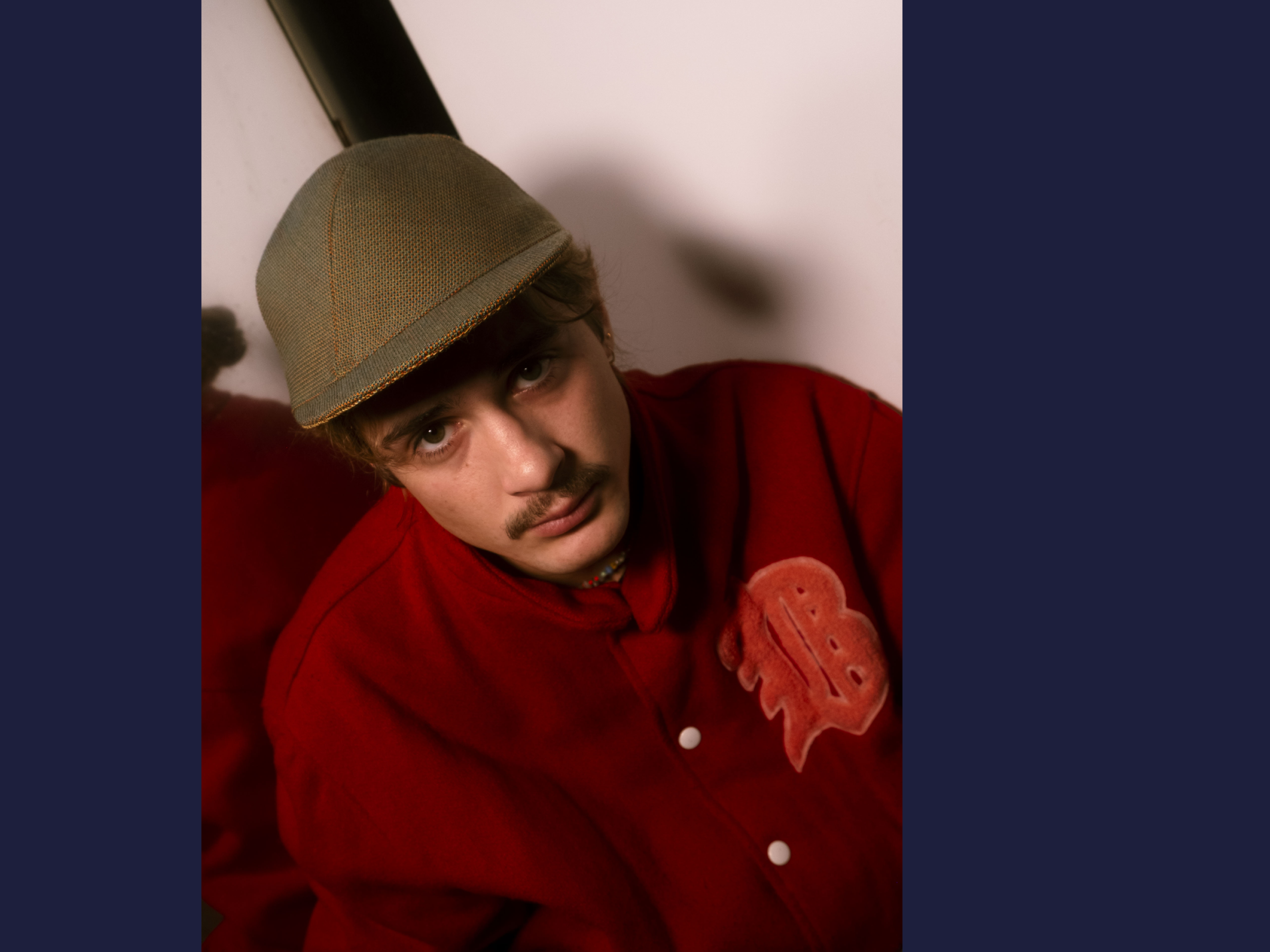 N°100_Orange-green wool cap_Le Panache Paris© Paul is wearing a Le Panache Paris© cap made in France with Morph_10102, fabric from the Gabriel© brand, 85% New Zealand wool and 15% polyamide in green color and orange reflections.